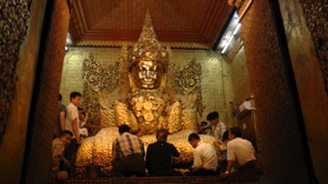 People apply gold on this statue of Buddha in  Mandalay